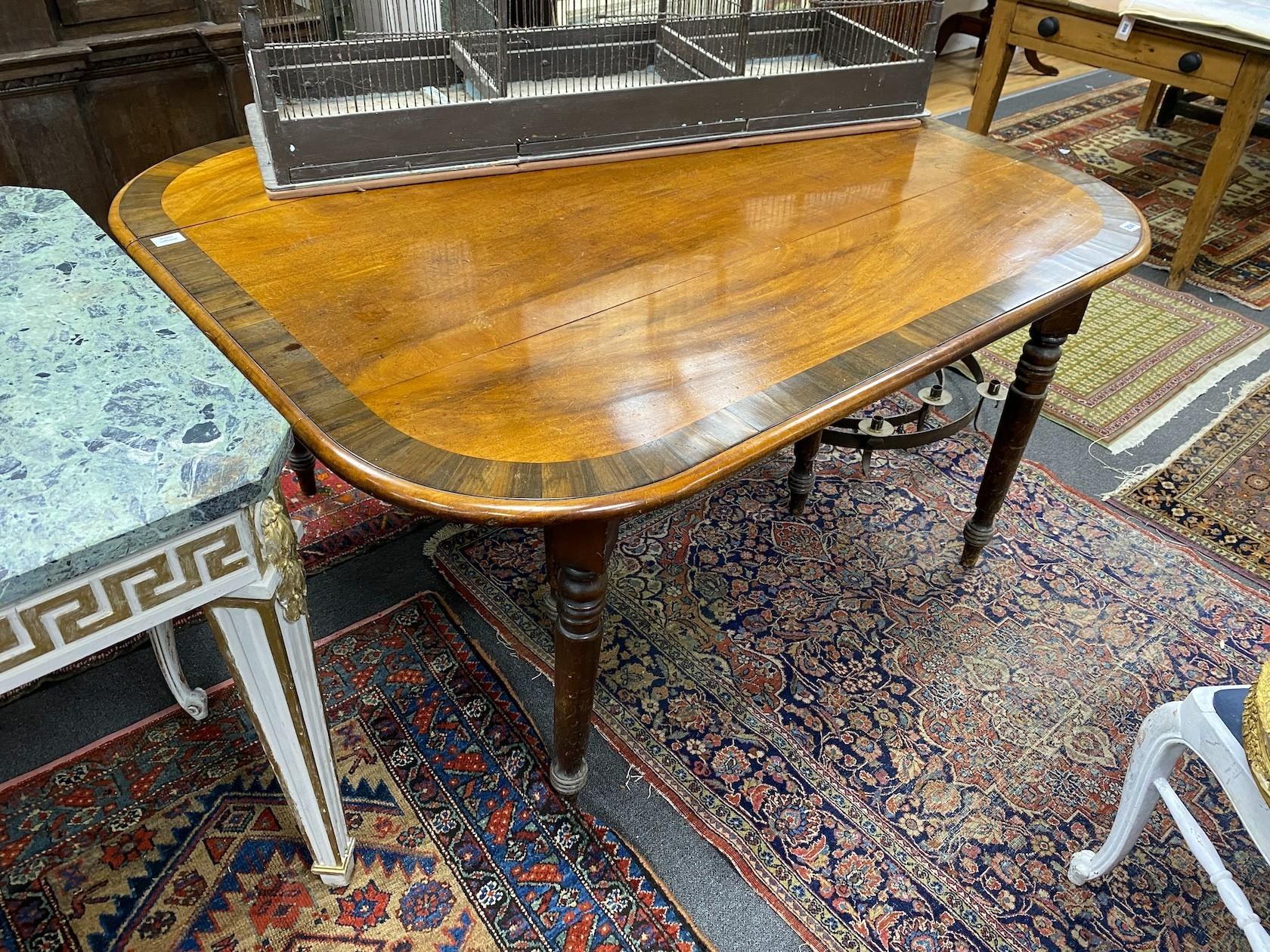 A Regency mahogany and rosewood banded gateleg dining table, width 122cm extended, depth 145cm, height 72cm
